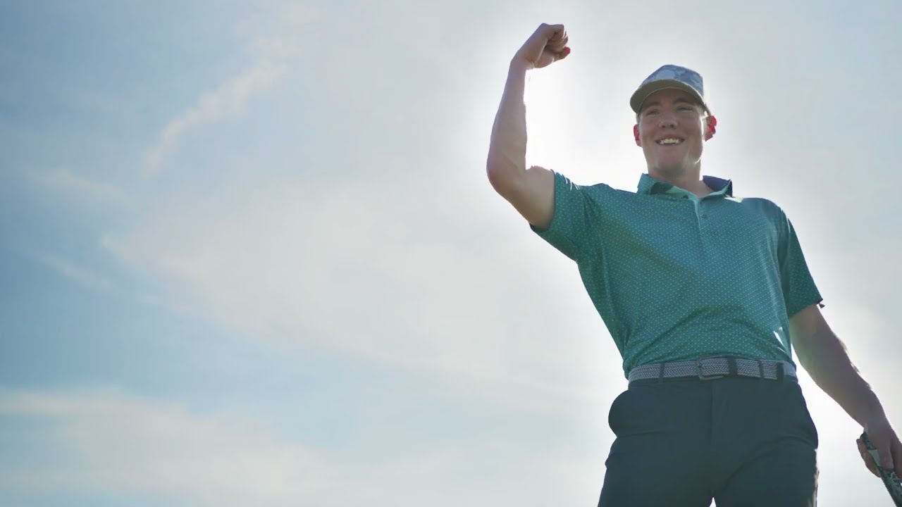 A golfer celebrating against a bright sky